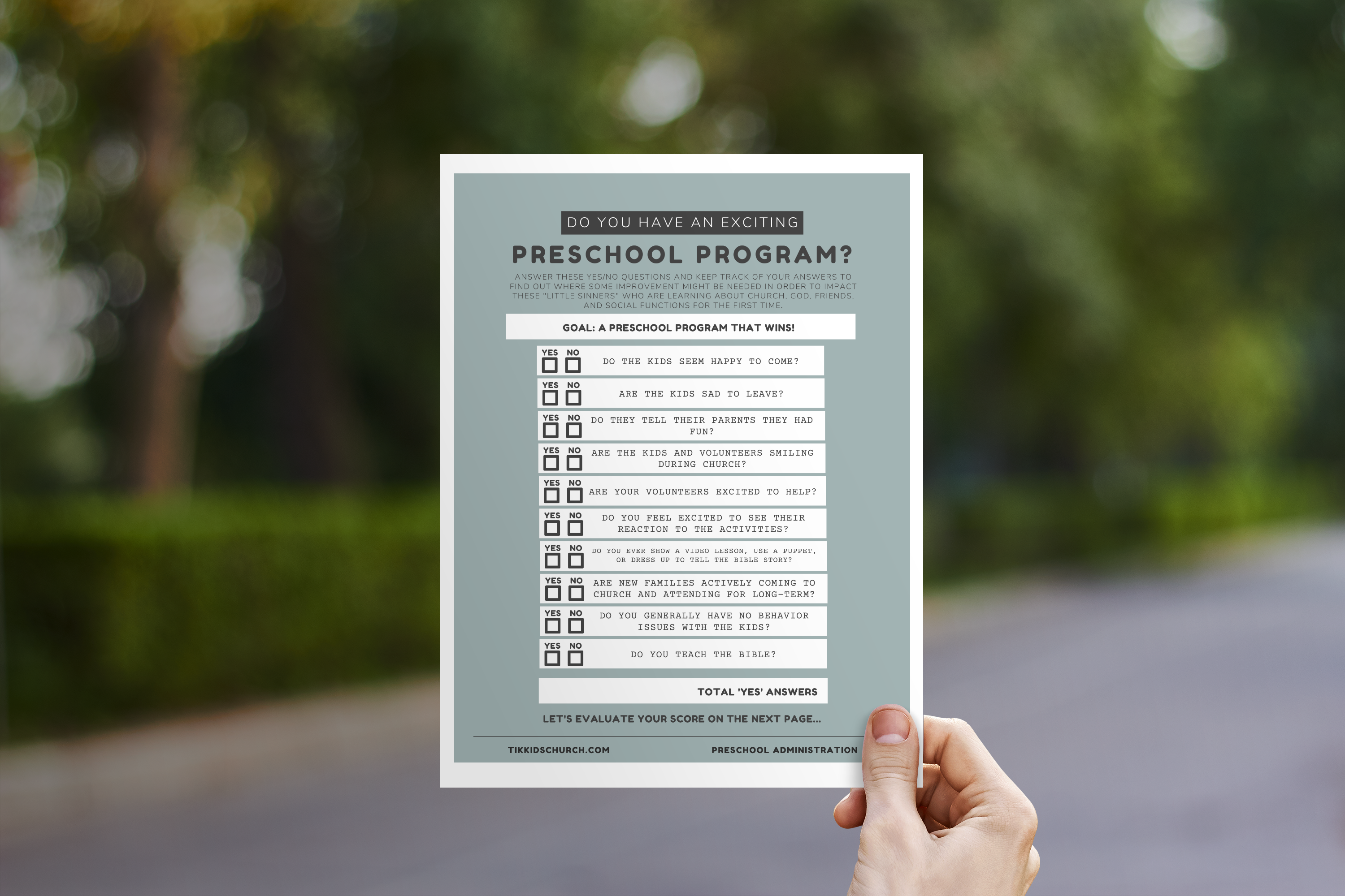 Person holding a checklist for an exciting preschool program against a blurred outdoor background