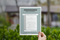 Hand holding a paper with a checklist against a blurred outdoor background